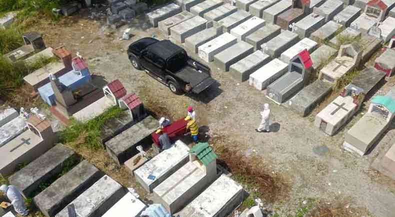 Funcionrios de cemitrio de Guayaquil, no Equador, neste domingo(foto: Jose Snchez / AFP)