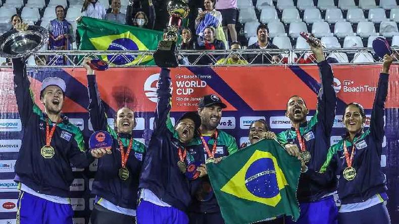 Mulheres e homens levantando trofus e mostrando medalhas