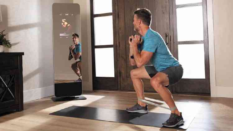 Homem se exercita com espelho fitness inteligente