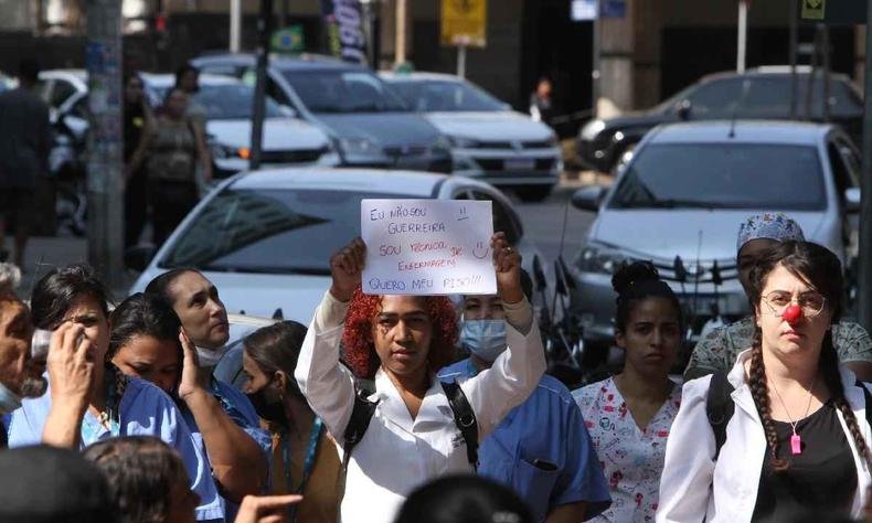Mulher segurando uma placa escrito 'n�o sou guerreira, sou t�cnica em enfermagem', na manifesta��o