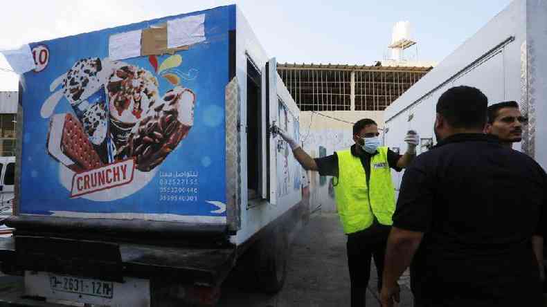 Policial usa caminho de sorvete para colocar corpos no Hospital dos Mrtires de Al Aqsa, na Faixa de Gaza