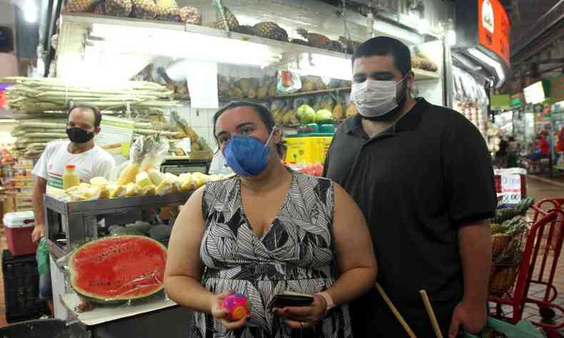casal usando mscaras durante compras no Mercado Central