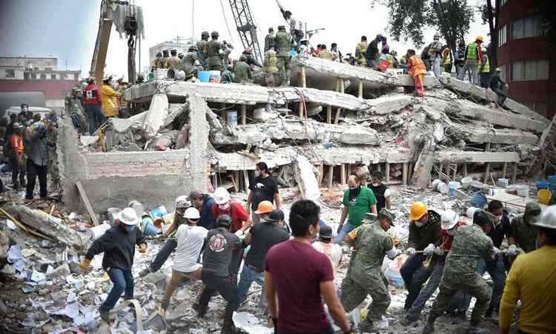 Bombeiros e voluntrios procuram sobreviventes em prdio que desabou na Cidade do Mxico (foto: YURI CORTEZ/AFP)