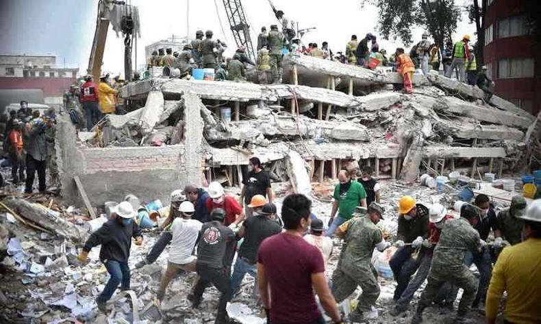 Bombeiros e voluntrios procuram sobreviventes em prdio que desabou na Cidade do Mxico (foto: YURI CORTEZ/AFP)