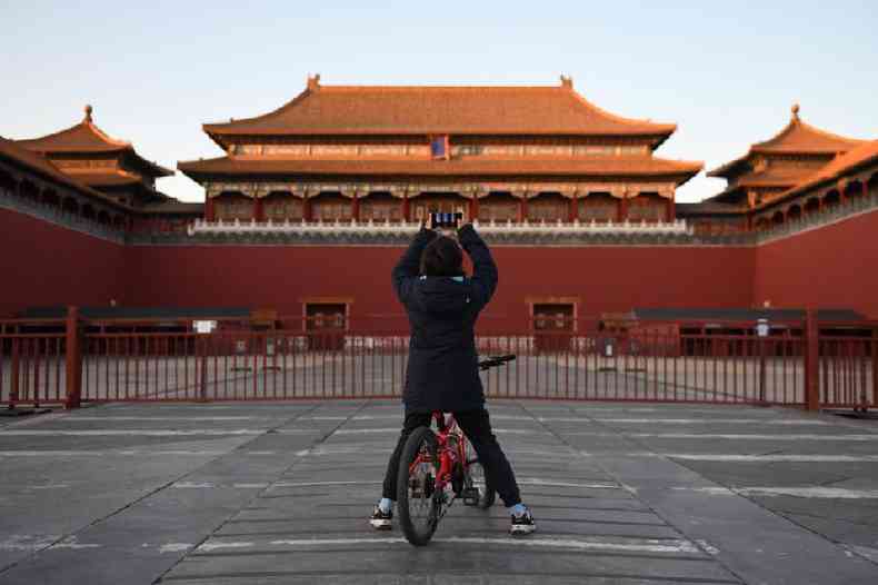 Um jovem tira foto da Cidade Proibida, fechada devido  pandemia de coronavrus, em Pequim, em 4 de fevereiro de 2020 (Greg Baker / AFP)