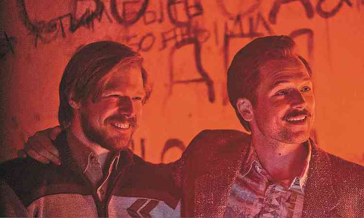 Os atores Nikita Efremov e Taron Egerton sorriem em cena de 'Tetris'