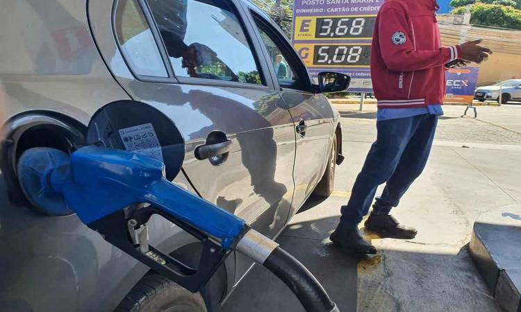 carro sendo abastecido em posto de gasolina