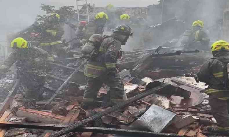 bombeiros em telhado incendiado