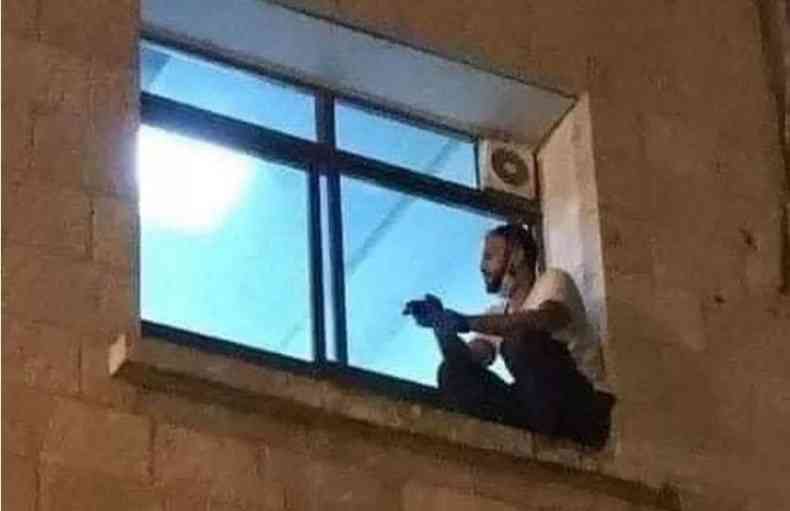 Impedido de entrar no hospital, Jihad Al-Suwaiti subiu at a janela para ver a me (foto: Twitter/Reproduo)