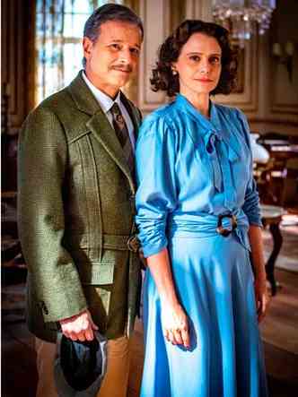 O ator Marcello Novaes, de casaco xadrez, está ao lado de Malu Galli, de vestido azul, em cena da novela Além da ilusão