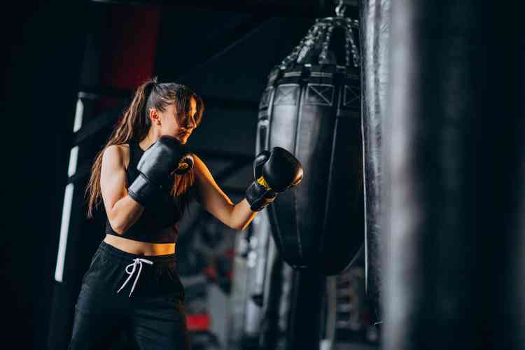 Mulher lutando boxer na academia