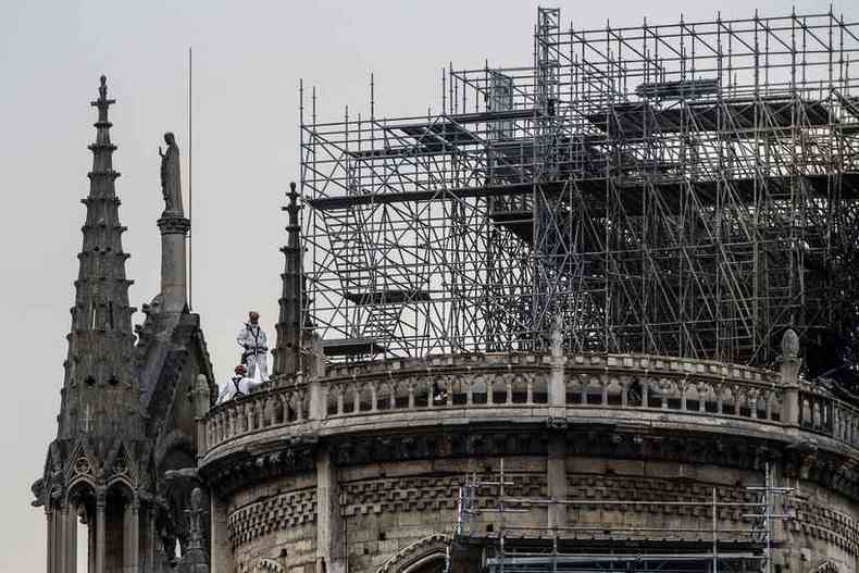 Trabalhadores escalam as torres de Notre-Dame para cobrir a catedral, devastada pelo fogo h uma semana(foto: CHRISTOPHE ARCHAMBAULT / AFP)