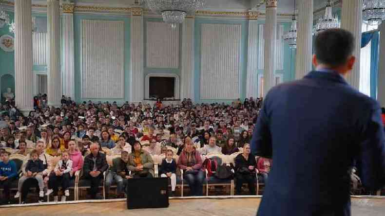 Pastor fala em palco a centenas de fiis sentados