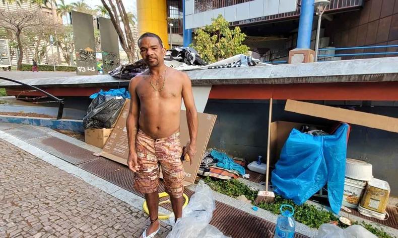 Catador Evaldo Xavier aparece sem camisa e de bermuda. Atrs dele uma estrutura montada onde se protege da chva e do frio