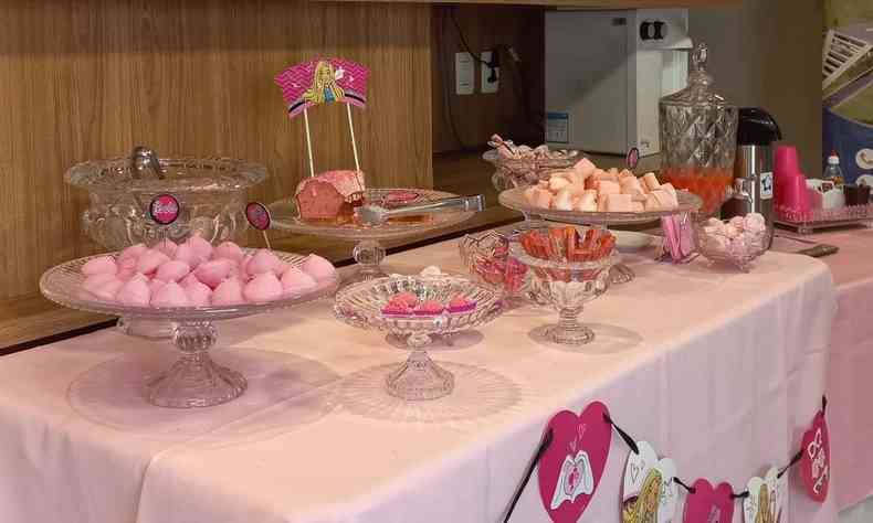 Mesa decorada de rosa com doces e bolo rosa 