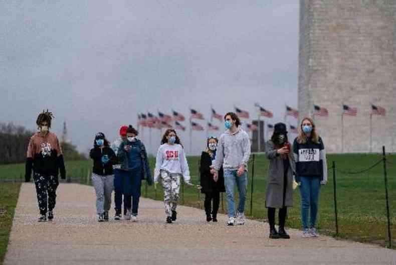 Jovens caminham usando mscaras faciais em Washington, a capital dos EUA(foto: Alex Edelman/AFP)