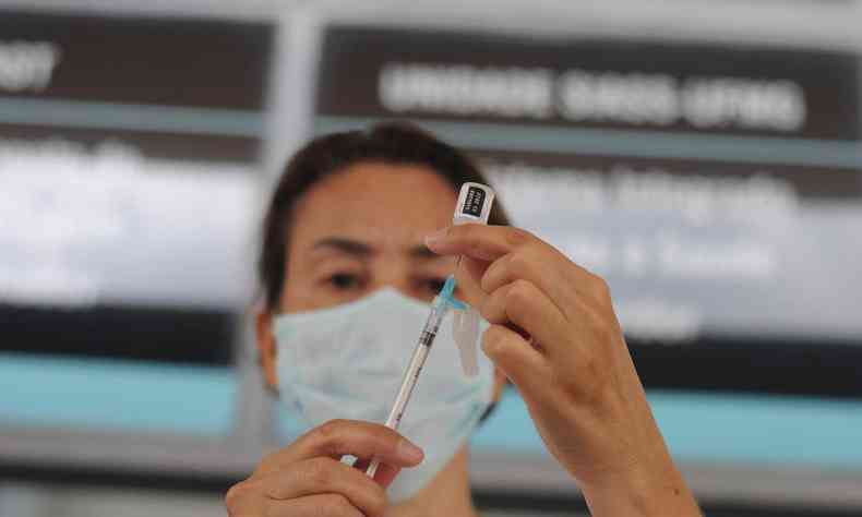 Enfermeira segurando seringa com vacina 