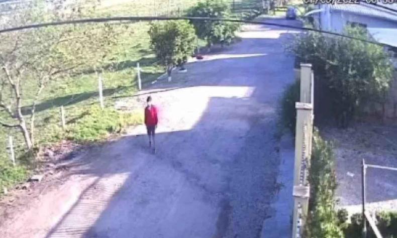 Escola da criança fica a 1km de casa, o pai voltou para buscar o filho(foto: Reprodução/Redes sociais) Criança sozinha na rua de camisa vermelha, na porta de casa