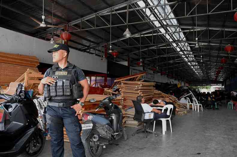 Policial vigia complexo invadido pela polcia e resgatou mais de mil pessoas supostamente traficadas para trabalhar em um cassino online no pas