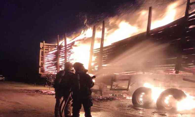 militares dos bombeiros jogando gua em carga pegando fogo na rodovia 