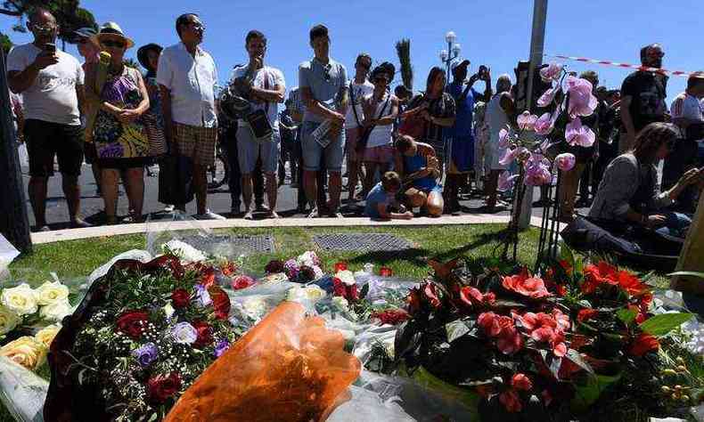 Flores e velas so colocadas perto do local em Nice, onde um pistoleiro atropelou com um caminho uma multido de folies que comemoram o Dia da Bastilha, matando pelo menos 84 pessoas(foto: AFP/BORIS HORVAT)