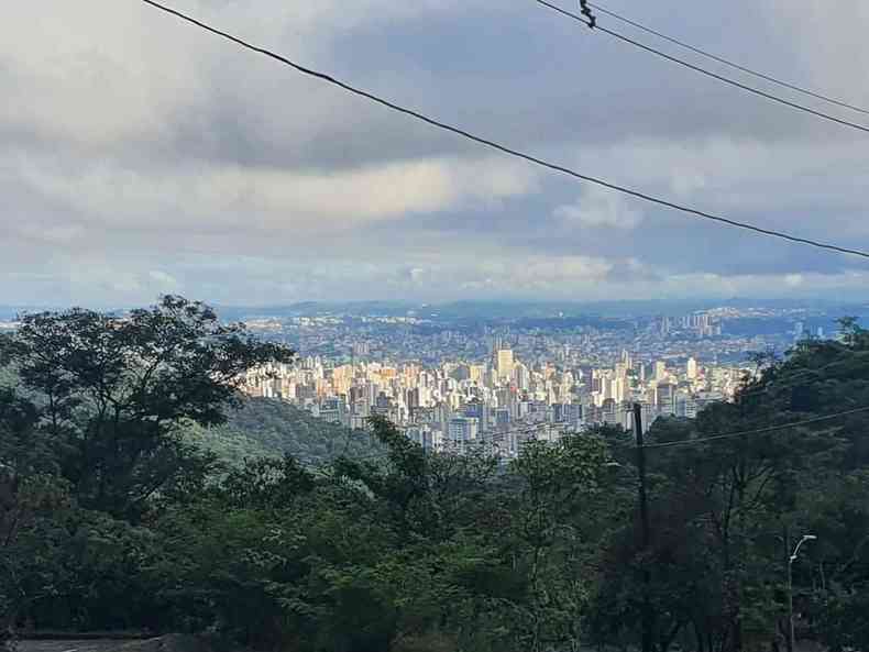 Belo Horizonte amanheceu nublada e h previso de chuva e queda de granizo vista panormica de mata e montanhas com os prdios da capital