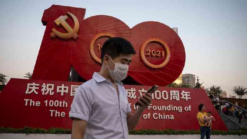 Pessoas tirando fotos em frente a uma placa que comemora o 100 aniversrio da fundao do Partido Comunista da China em Xangai
