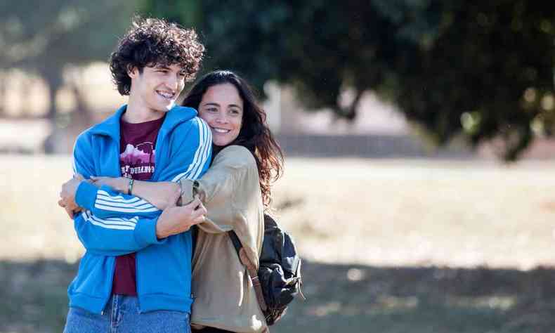 Atores Gabriel Leone e Alice Braga se abraçam no parque em cena do filme Eduardo e Mônica