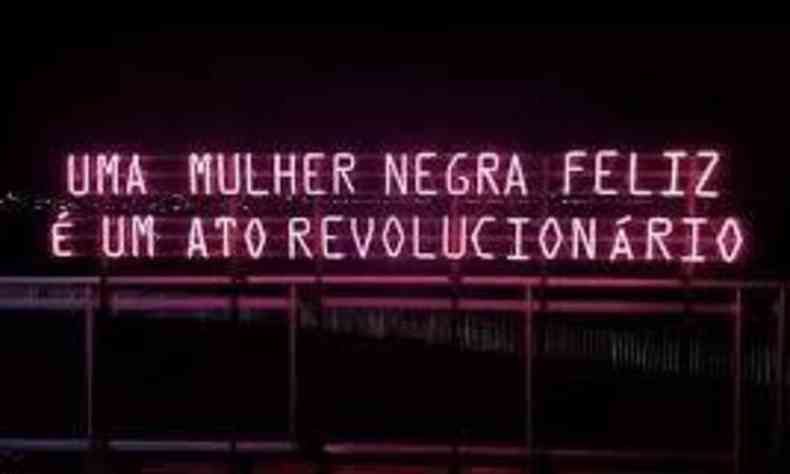 Letreiro neon no qual se l 'Uma mulher negra feliz  um ato revolucionrio'