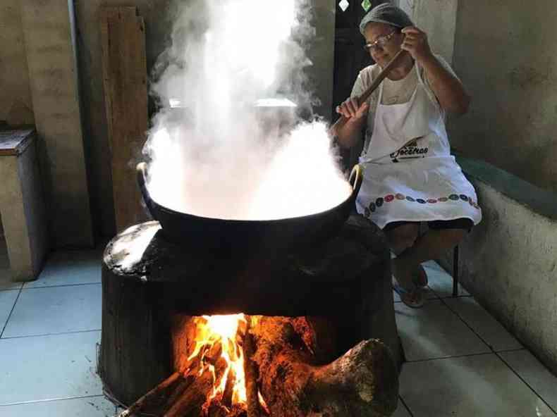 Mulher fazendo doce em fogo a lenha