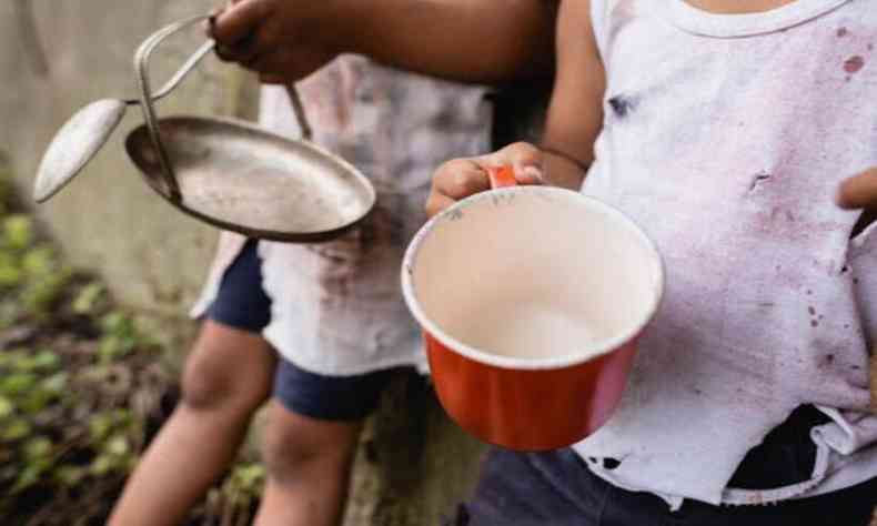 crianas mostrando prato e panela vazios; seus rostos no aparecem na foto