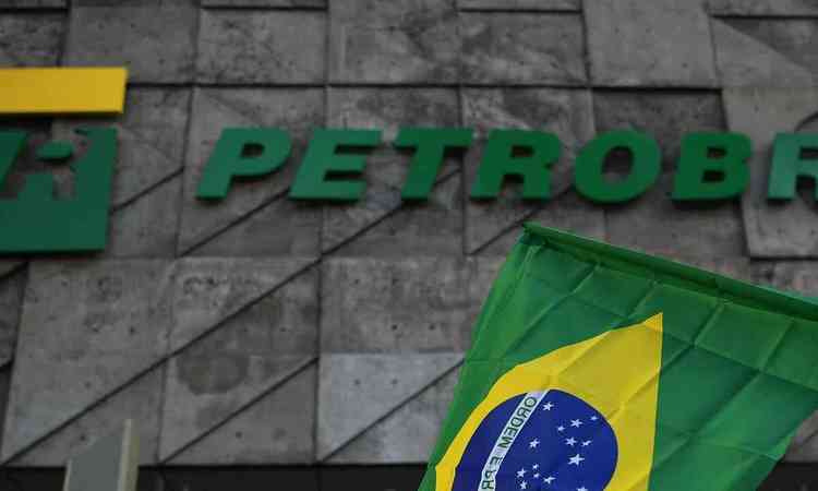 Imagem da fachada da Petrobras com uma bandeira do Brasil em primeiro plano