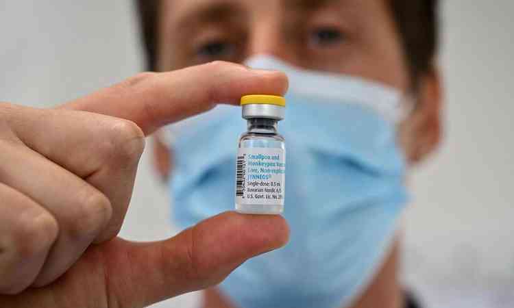 Homem segurando tubo de vacina de monkeypox
