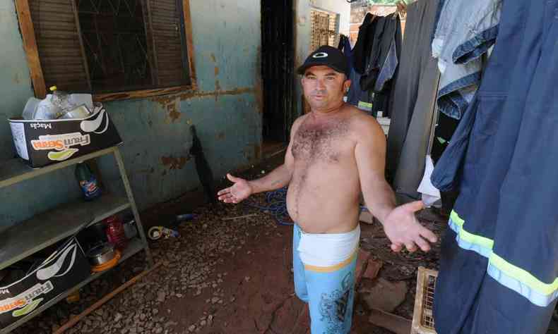Morador sem blusa faz gesto com os braços abertos em meio à lama que invadiu sua casa há 12 dias, em Brumadinho
