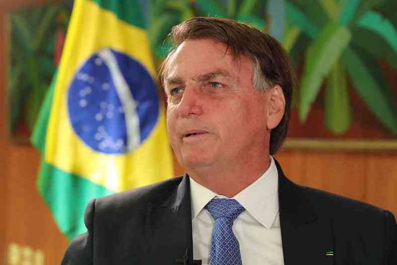 Bolsonaro em gabinete com bandeira do Brasil