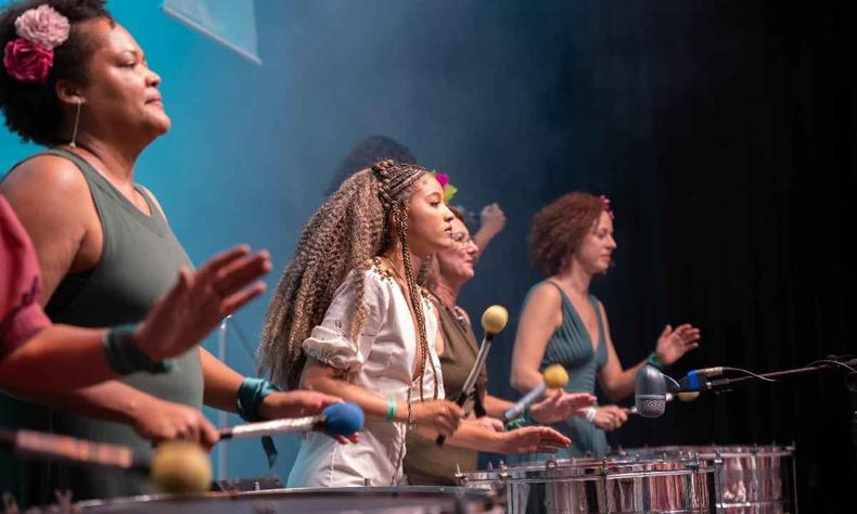 Quatro mulheres negras se apresentando no palco do Sesc Palladium tocando instrumentos de percusso 
