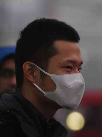 Por causa da poluio, jovem usa mscara ao andar pelas ruas de Pequim, na China(foto: GREG BAKER / AFP)