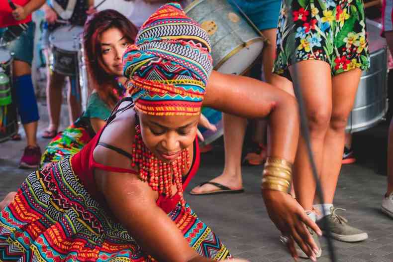 Mulher danando com roupas tradicionais de religies de matriz africana.