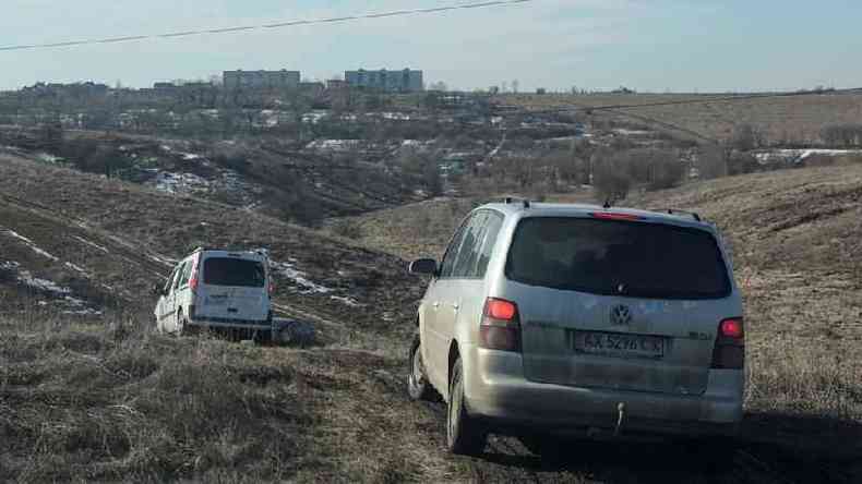 Carros atravessando campos para deixar Kharkiv