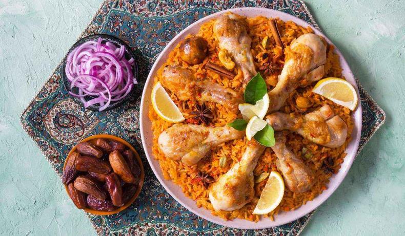 Foto de Majboos, um arroz temperado com curry e cravo servido com pedaos de frango, principalmente peito e coxa