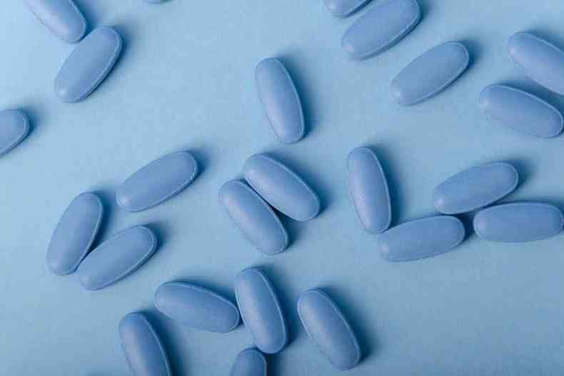 Comprimidos do Viagra azuis sobre fundo azul mais claro