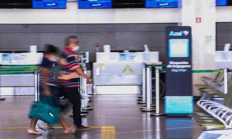 Imagem distorcida de duas pessoas de mscara dentro de um aeroporto