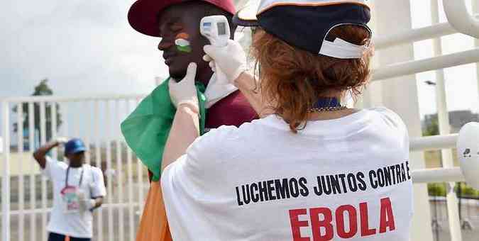 Voluntrio confere temperatura corporal de homem antes de partida vlida pela Copa da frica, em Guin Equatorial. Ebola j matou mais de nove mil pessoas(foto: AFP Photo/Issouf Sanogo )