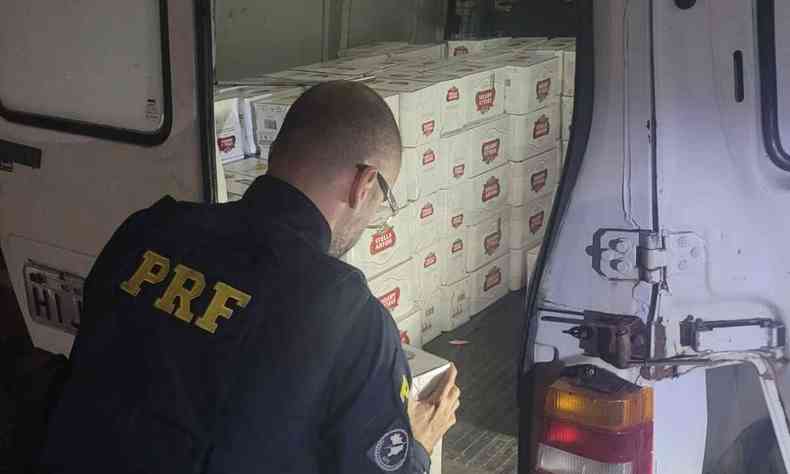 Policial verifica carregamento de cerveja em carroceria de carro