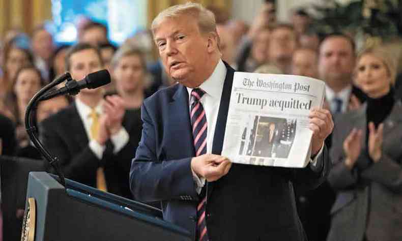  Presidente dos Estados Unidos exibe jornal com a manchete da sua absolvio no Senado (foto: Saul Loeb/AFP)