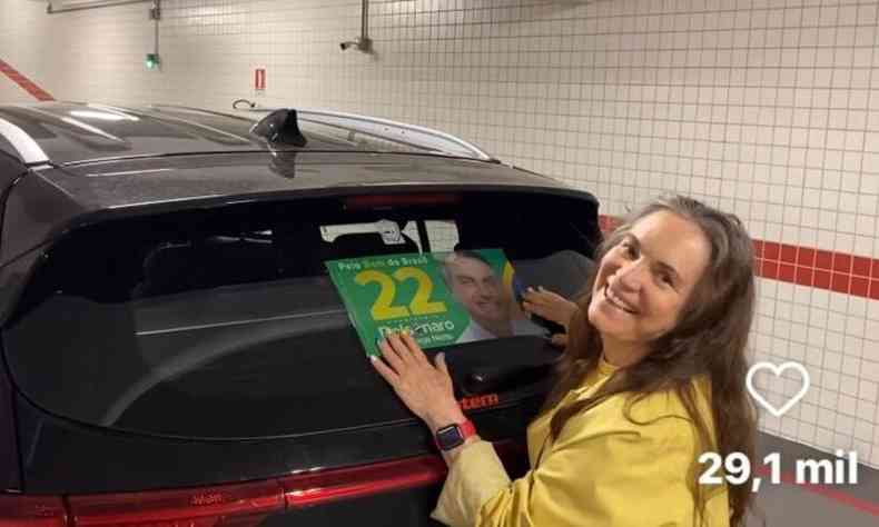 Regina Duarte sorri e cola adesivo no carro com o nmero de urna do presidente Jair Bolsonaro