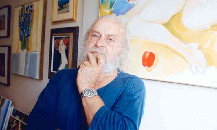 Konstantin Christoff olha para a cmera, tendo pinturas atrs de si