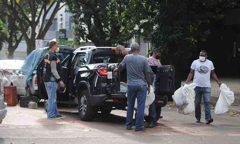 Momento em que fiscais colocam abacaxis em caminhonete com logo da prefeitura na Avenida Caranda, Centro-Sul de BH