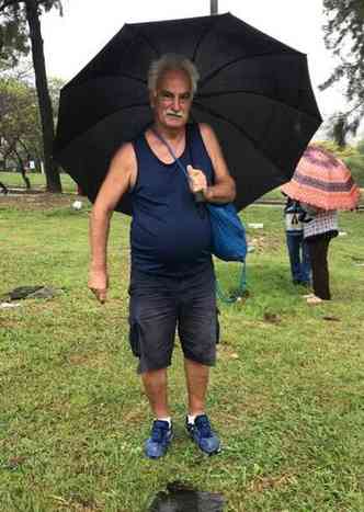 Srgio Antnio de p com um guarda-chuva no Cemitrio da Paz