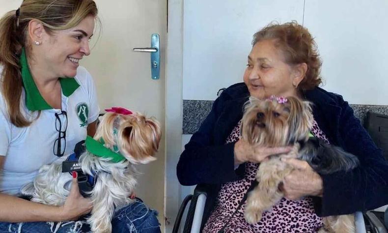 Carinho dos pets faz bem para a saúde(foto: Hospital Madre Tereza/divulgação) Funcionária e paciente de hospital seguram cachorros no colo